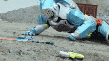 a person in a robot costume is crawling on the ground with a sword .
