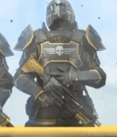a soldier in armor is holding a gun with a skull on his back .