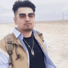 a man wearing sunglasses and a necklace with a key pendant on it