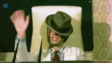 a man wearing a hat is sitting in a chair