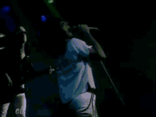a person is singing into a microphone on a stage .