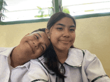 a boy and a girl are posing for a picture with their heads together