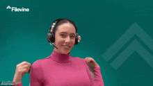 a woman wearing headphones and a pink turtleneck is dancing .