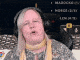 a woman wearing headphones is sitting in front of a screen that says marocko on it