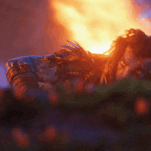 a person laying in front of a fire with a purple background