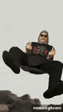 a man is flying through the air while sitting on a rock .