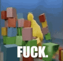 a yellow duck is standing in front of a pile of colorful blocks with the word fuck written on the bottom
