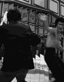 a man without a shirt is fighting another man in a black and white photo