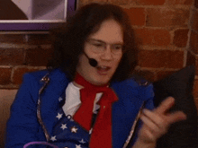 a man wearing glasses and a microphone is pointing at something