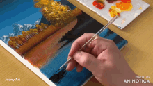 a person is painting a landscape on a canvas with the words made in animotica below it