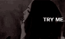 a black and white photo of a woman talking on a cell phone with the words try me written above her