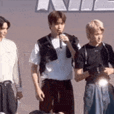 a group of young men are standing next to each other on a stage .
