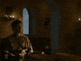 a man sitting in a dark room with a woman standing next to him