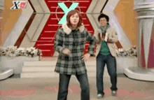 two people are dancing in front of a sign that says x