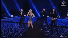 a group of people are singing and dancing on a stage with a gifs.com logo in the corner