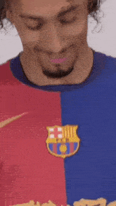 a man with curly hair and a beard is wearing a barcelona shirt .