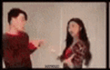 a man and a woman are standing next to each other in a room .