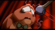 a cartoon worm wearing a bow tie is looking at a microphone