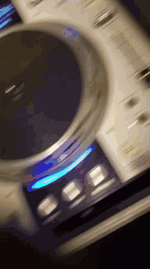 a blurred image of a dj controller with a blue light on the bottom