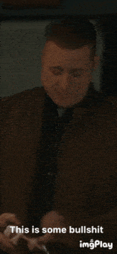 a man in a brown jacket is holding a bottle of beer and says this is some bullshit imgplay