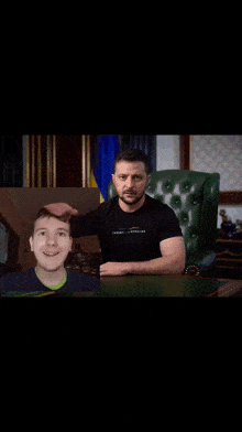 a man in a tommy hilfiger shirt sits in a chair