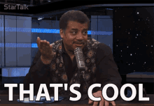 a man talking into a microphone with the words that 's cool below him
