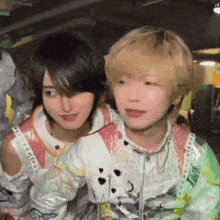 a man and a woman are standing next to each other in a room and looking at the camera .