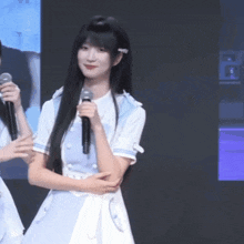 a girl with long black hair holding a microphone