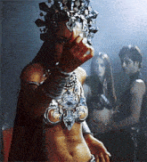 a woman with a crown on her head is standing in front of a group of people