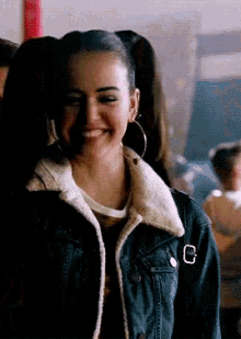 a girl wearing a denim jacket with a letter c on the sleeve