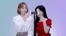 two girls are standing next to each other and one has a device on her ear that says ' earphone ' on it