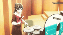 a girl playing drums in front of a yamaha drum set