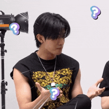 a man wearing a black sleeveless t-shirt with a question mark around his neck