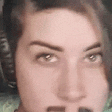 a close up of a woman 's face with headphones and a microphone .