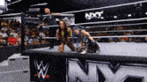 two women are wrestling in a ring with nxt written on the side