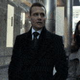 a man in a suit and tie is walking down a street