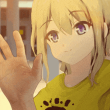 a girl with purple eyes is wearing a yellow shirt with a paw print
