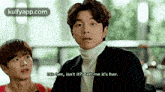 a man in a suit and turtleneck sweater is talking to another man .