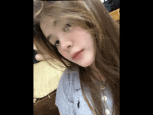 a girl with long hair is wearing a polo shirt and looking at the camera