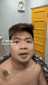a man without a shirt has a tattoo on his chest that says ' a ' on it