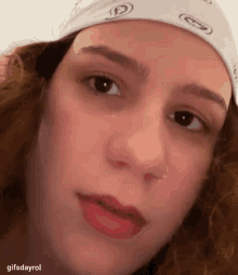 a close up of a woman wearing a bandana on her head .