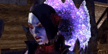 a woman with a flower in her hair is standing in front of a purple light .
