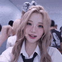 a girl wearing a tie and a scrunchie looks at the camera