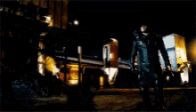 a man in a superhero suit is standing in the dark