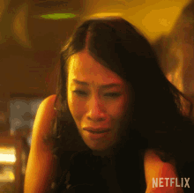 a woman is crying in front of a netflix sign