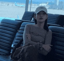 a woman wearing a hat that says ' airways ' on it sits in a chair