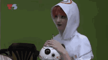 a woman in a star wars costume holds a bb-8 toy