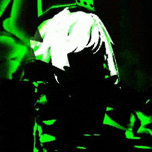 a person is standing in a dark room with a green light shining on them .