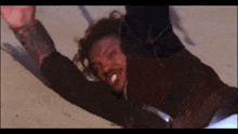 a man is laying on the ground with his arms up in the air .