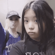 a girl wearing a celine hat and a girl wearing a black shirt